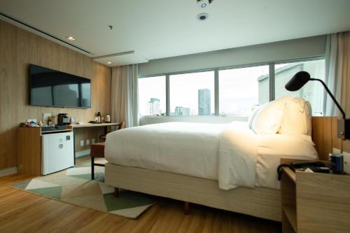 a bedroom with a large bed and a large window at Radisson Vila Olimpia Sao Paulo in São Paulo