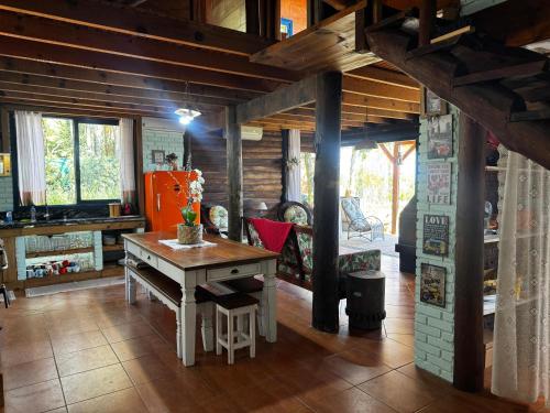a living room with a table and a fireplace at Pousada das Nuvens in Nova Petrópolis