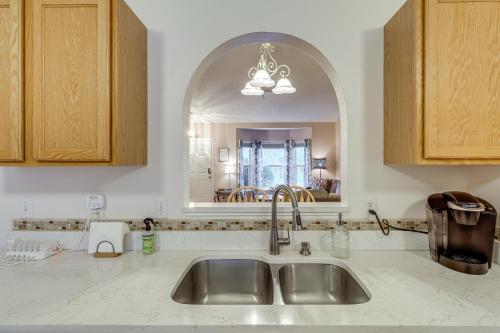 a kitchen with a sink and a mirror at 15 Mi to Melbourne Beach Peaceful Palm Bay Escape in Palm Bay