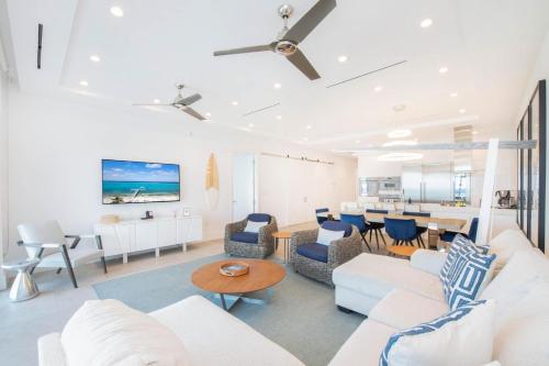 un soggiorno con mobili bianchi e una sala da pranzo di Rum Point Resort 406 a Driftwood Village