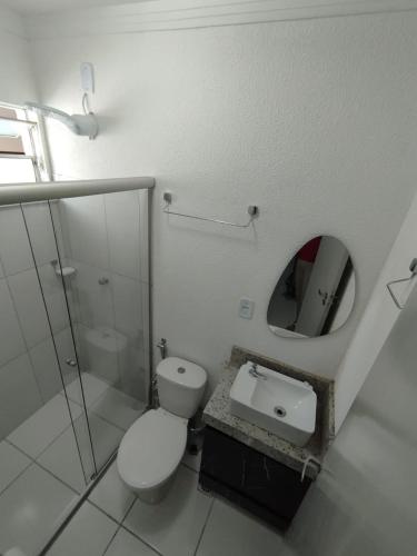 a bathroom with a toilet and a mirror at Apto Top Completo in Aracaju