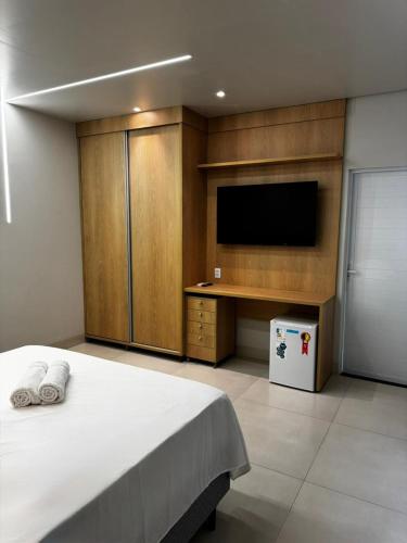 a bedroom with a large bed and a tv at Villa Hotel in Bom Jesus da Lapa