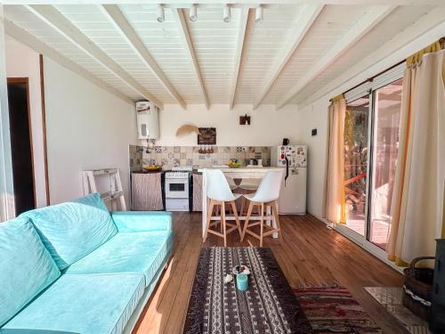 a living room with a blue couch and a kitchen at Casa Joha - Casa en Chapa a 1 cuadra de Luna Roja para 4 PAX - Hola Sur in Chapadmalal