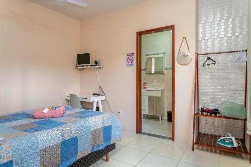 a bedroom with a bed and a desk and a mirror at Casa perto do centro e da Udesc Cefid in Florianópolis