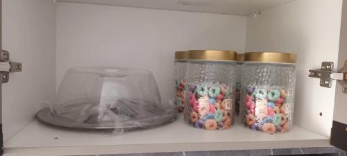 three jars filled with candy on a shelf at Apto Top Completo in Aracaju