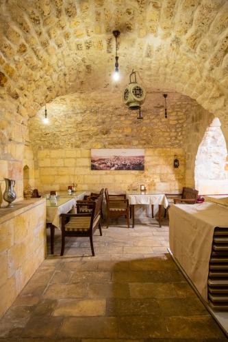 a dining room with a table and a stone wall at Turkmen Konagi in Urfa