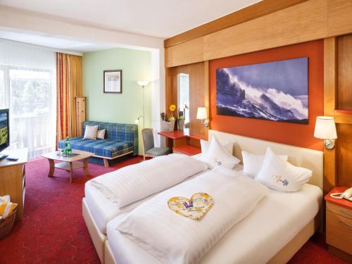 ein Hotelzimmer mit einem Bett mit Herz darauf in der Unterkunft Familienhotel Hinteregger in Katschberghöhe