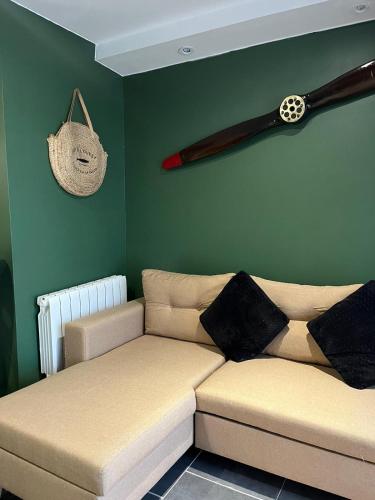 a living room with a couch and a baseball bat on the wall at Studio privé tout équipé in Roquefort-sur-Garonne