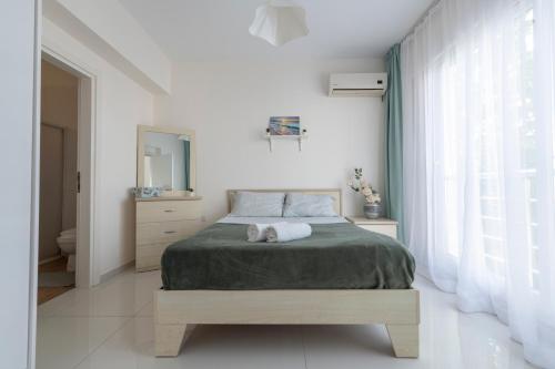 a white bedroom with a bed and a window at Трехкомнатные апартаменты в жилом комплексе Caesar Beach D2 Flat16 in Boğaz