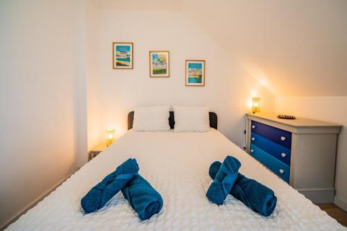 a bedroom with a bed with blue bow ties on it at La Pause Tourangelle - Calme - Wifi - Parking in Monnaie