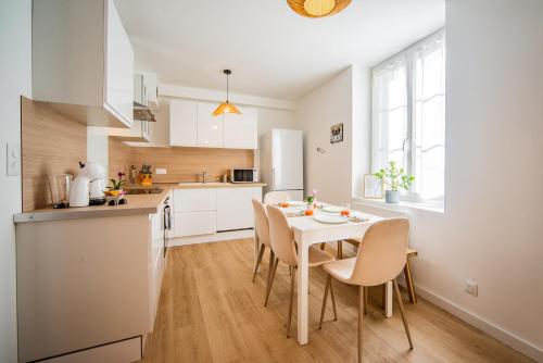 a kitchen and dining room with a table and chairs at La Pause Tourangelle - Calme - Wifi - Parking in Monnaie