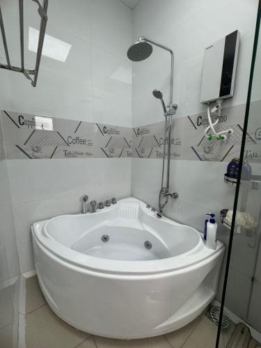 a white tub in a bathroom with a shower at Two-bedroom flat - River view, elevator, free inside car parking in Mỹ Phước