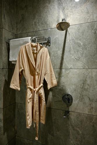 a robe hanging in a shower in a bathroom at The Nest in Varanasi