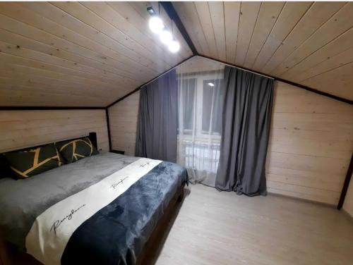 a bedroom with a bed in a room with a window at Подих Карпат in Volosyanka