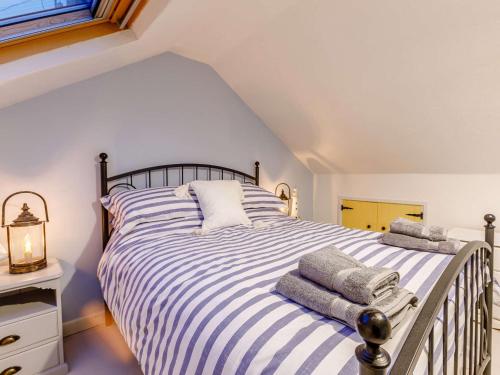 ein Schlafzimmer mit einem gestreiften Bett mit Handtüchern darauf in der Unterkunft 4 Bed in Bideford 85720 in Bideford