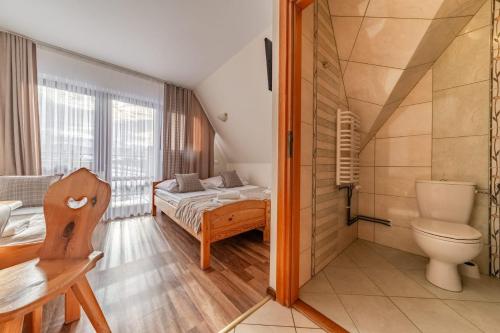 a small room with a bed and a toilet at Willa Leśny Potok in Poronin