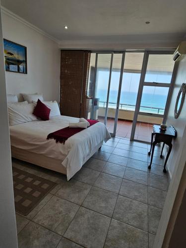 a bedroom with a bed with a view of the ocean at Maya's Beachfront Haven in Westbrook