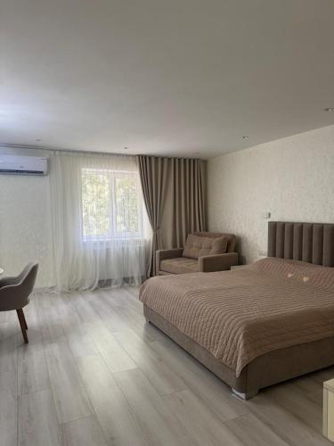 a bedroom with a bed and a chair and a couch at Samarkand Central Apartments in Samarkand