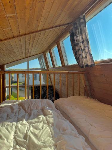 a bedroom with a bed in a room with windows at Dancamps Trelde Naes in Fredericia