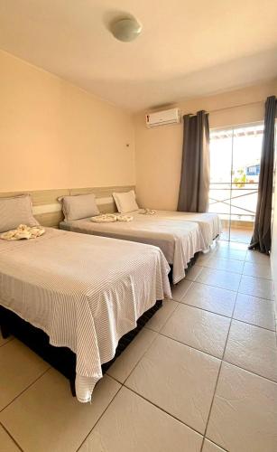 two beds sitting next to each other in a room at Apart Canoa Quebrada in Canoa Quebrada