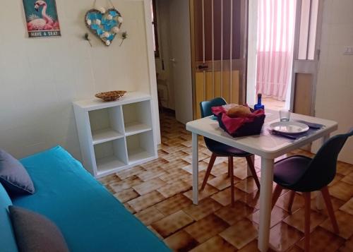 a living room with a table and chairs and a couch at Mare Sole Vento 38 Punta Prosciutto in Torre Colimena