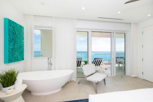 ein weißes Badezimmer mit einer Badewanne sowie einem Tisch und Stühlen in der Unterkunft Rum Point Resort 307 in Driftwood Village