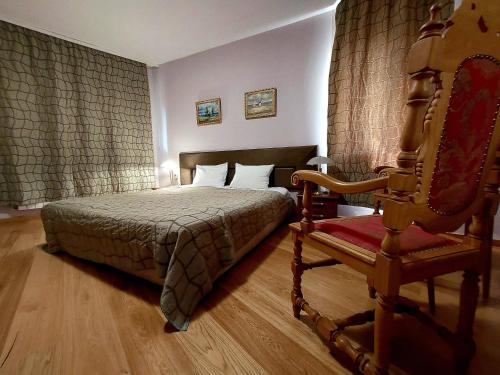 a bedroom with a bed and a chair in a room at Family Art Hotel Gallery in Pleven