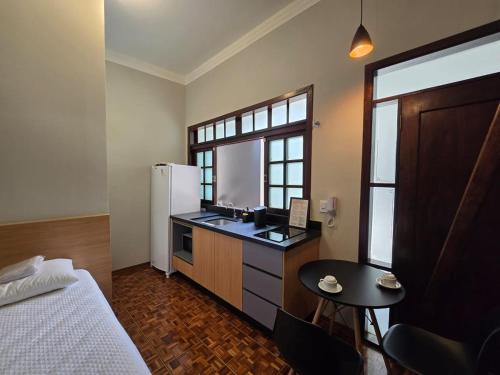 a small kitchen with a sink and a refrigerator at Zuccaro Studio 4 in Bauru