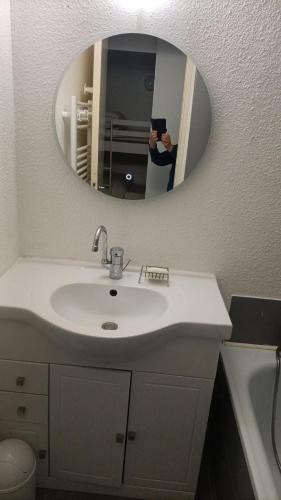 a person taking a picture of a bathroom sink at Studio 4pers vue piste in Le Corbier