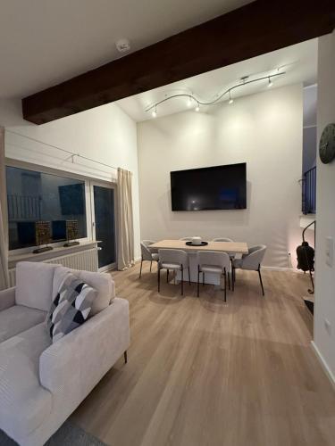 a living room with a couch and a table with chairs at Skywalk Loft Willingen in Willingen