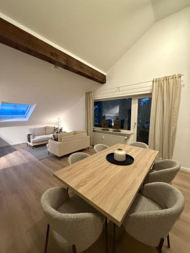 a living room with a wooden table and chairs at Skywalk Loft Willingen in Willingen