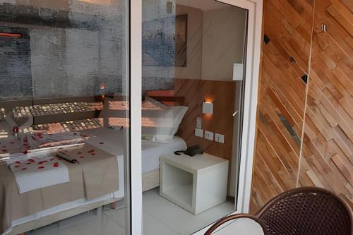 two views of a room with a bed and a table at Pipa's bay - Praia do Amor in Pipa