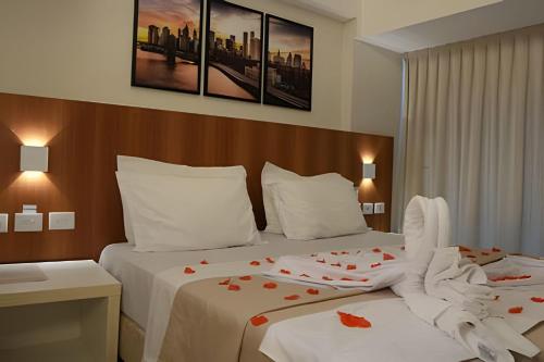 two beds in a hotel room with roses on them at Pipa's bay - Praia do Amor in Pipa