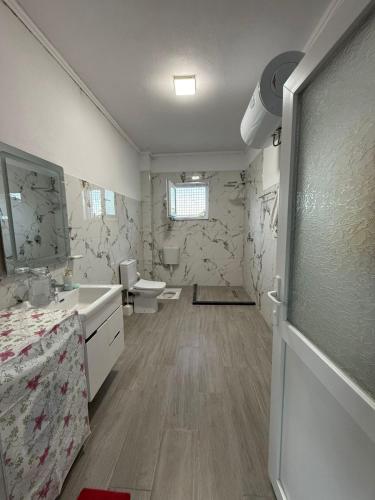 a bathroom with two toilets and a sink and a mirror at Bujtina e Kadrise in Kukës