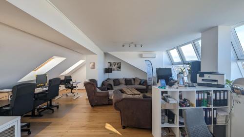 a living room with couches and desks and windows at Best Penthouse in Vienna, 7min to 1st district in Vienna