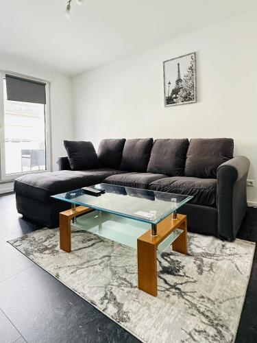 a living room with a black couch and a glass table at Apartment in Rittersdorf in Rittersdorf