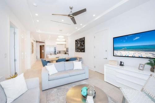 Driftwood VillageにあるRum Point Resort 308のソファと壁掛けテレビのあるリビングルーム