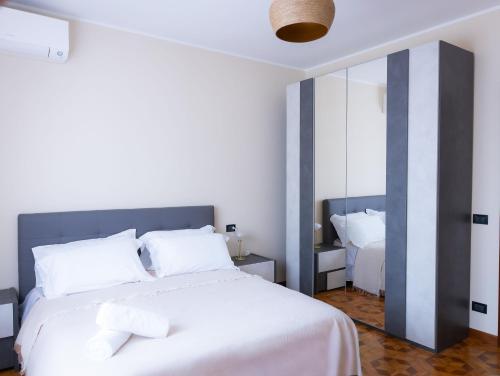 a bedroom with a white bed and a mirror at Civico 5 in Piacenza