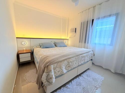 a small bedroom with a bed and a window at Lar e Mar PG in Praia Grande