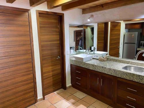 een badkamer met een wastafel en een grote spiegel bij Madchen in Puerto Vallarta