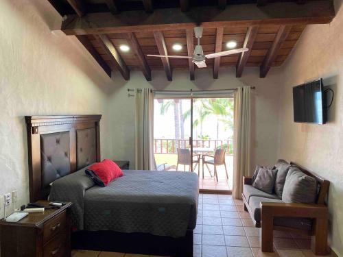 een slaapkamer met een bed, een bank en een televisie bij Madchen in Puerto Vallarta