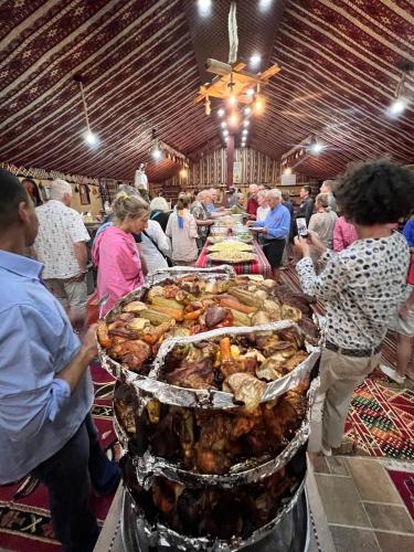 a group of people standing around a buffet of food at Wadi Rum Trip in Wadi Rum