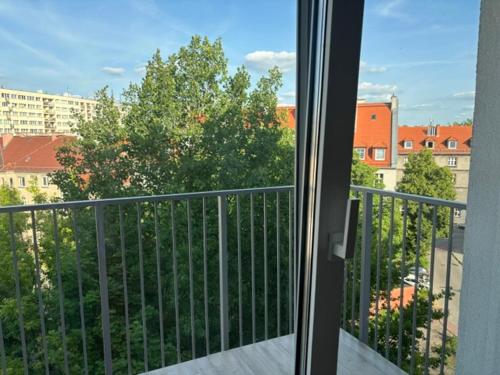 a balcony with a view of a building and trees at Mikołowska 9 pokój in Gliwice