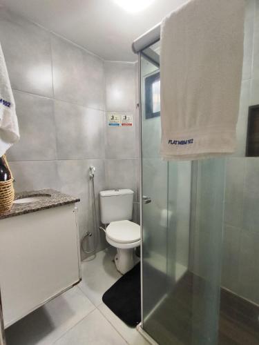 a bathroom with a toilet and a glass shower at Flat Beira-Mar Maragogi in Maragogi