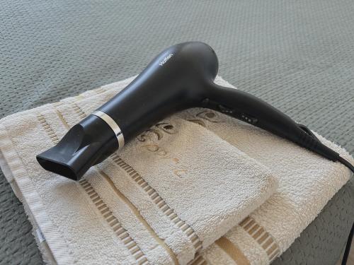 a black hair dryer sitting on top of a towel at Mikołowska 9 pokój in Gliwice
