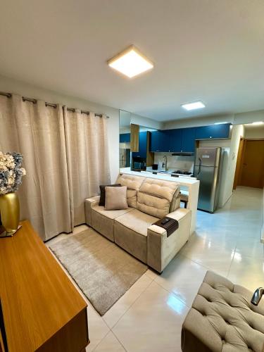 パリョサにあるApartamento NOVO e moderno em palhoçaのソファとキッチンのあるリビングルーム
