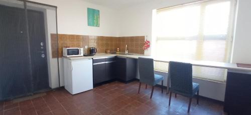 a kitchen with a table and chairs and a microwave at БіднийЗаяць in Lebedevka