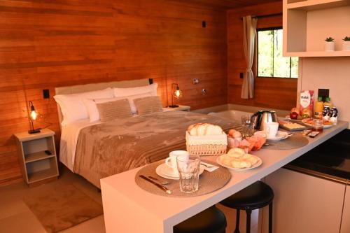 een slaapkamer met een bed en een tafel met eten erop bij Cabanas Rota do Vinho in São Joaquim