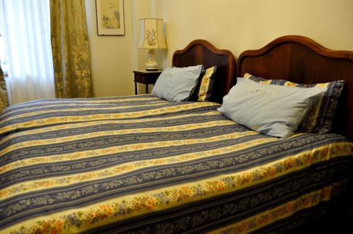 a bed with a colorful blanket and pillows on it at Le Macine Relais in Cairo Montenotte