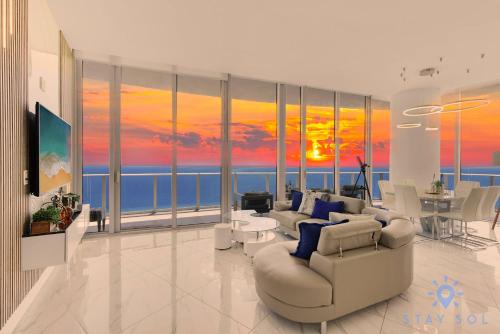 a living room with a sunset painting on the wall at Oceanfront Penthouse -3BR + Pool + Beach access in Hollywood Beach